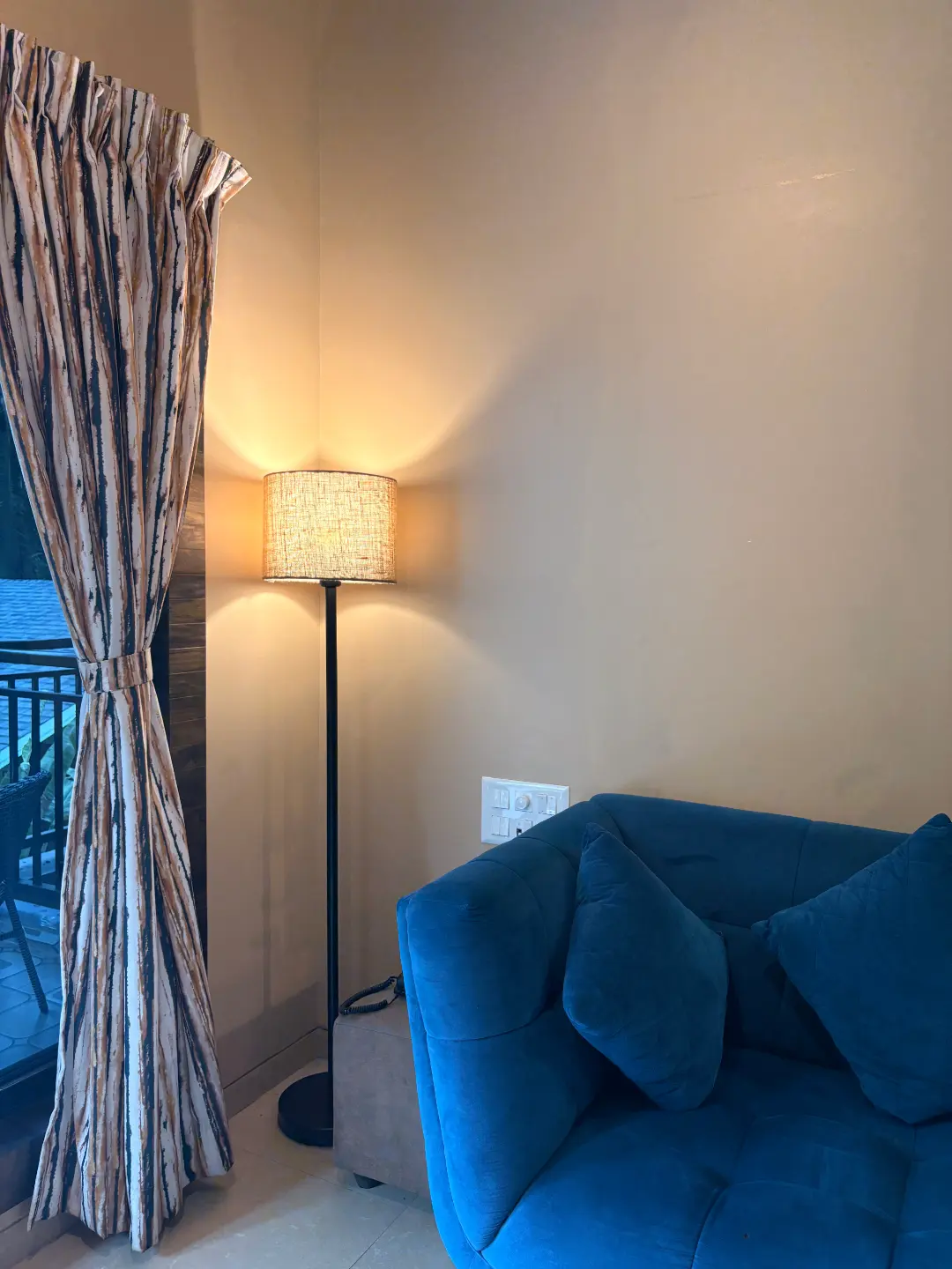 Room corner with floor lamp and blue armchair at The Coastal Heritage